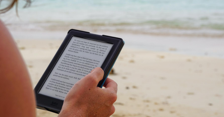 woman on beach reading ebook